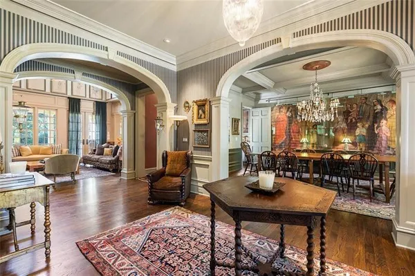 a living room with furniture a rug kitchen view and a chandelier