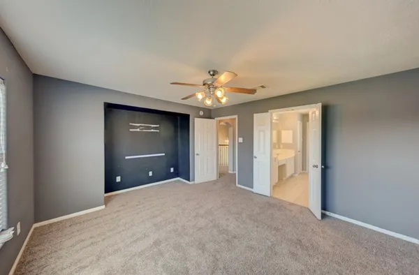 a view of a livingroom with a ceiling fan & entryway