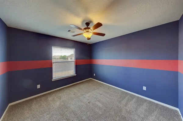 an empty room with a window and a ceiling fan