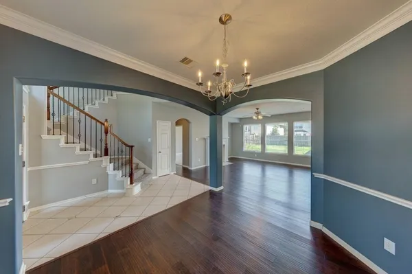 a view of a room with wooden floor chandelier and entryway