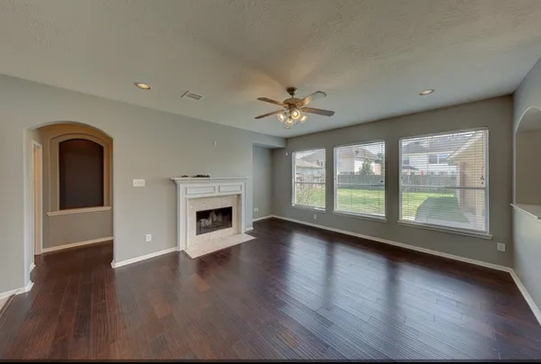 a view of an empty room with a window and wooden floor