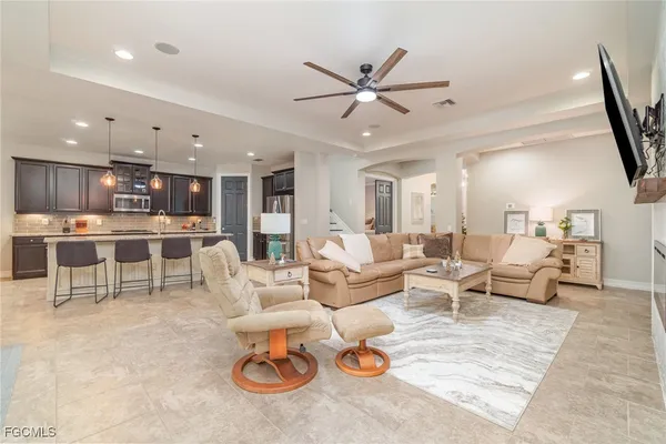a living room with lots of furniture and view of kitchen