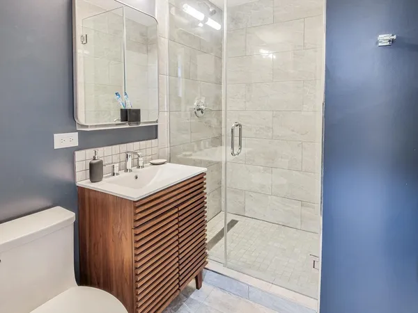 a bathroom with a sink a toilet and shower