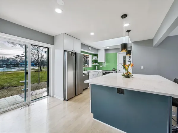 a kitchen with a refrigerator a sink and a large window