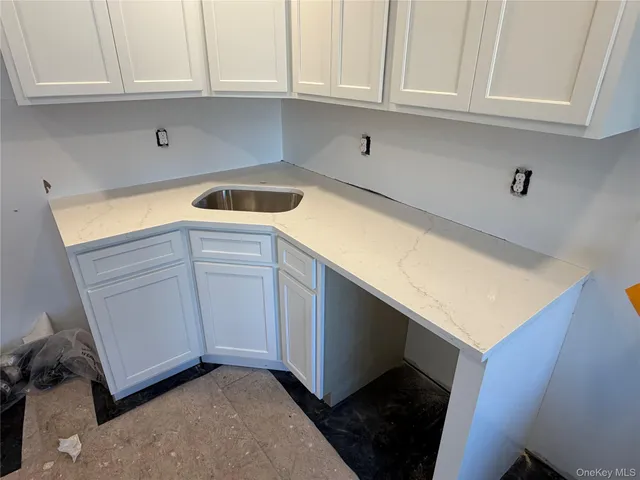 a kitchen with granite countertop white cabinets and sink