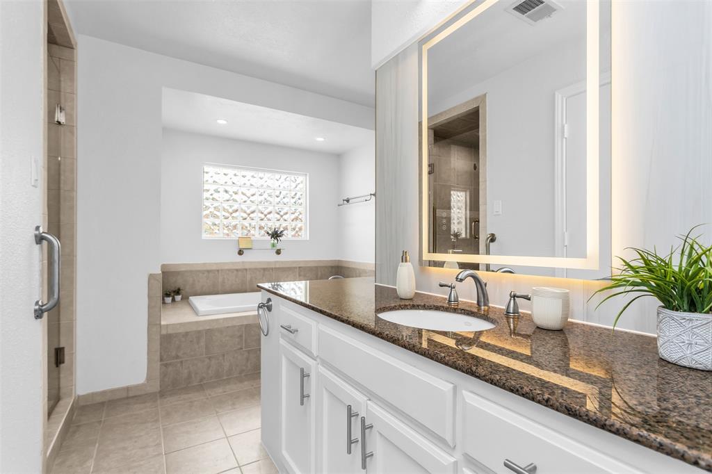 7233 Rustic Valley Drive Dallas, TX 75248 - Photo 12 of 21 a bathroom with a granite countertop sink a mirror a window and a bathtub