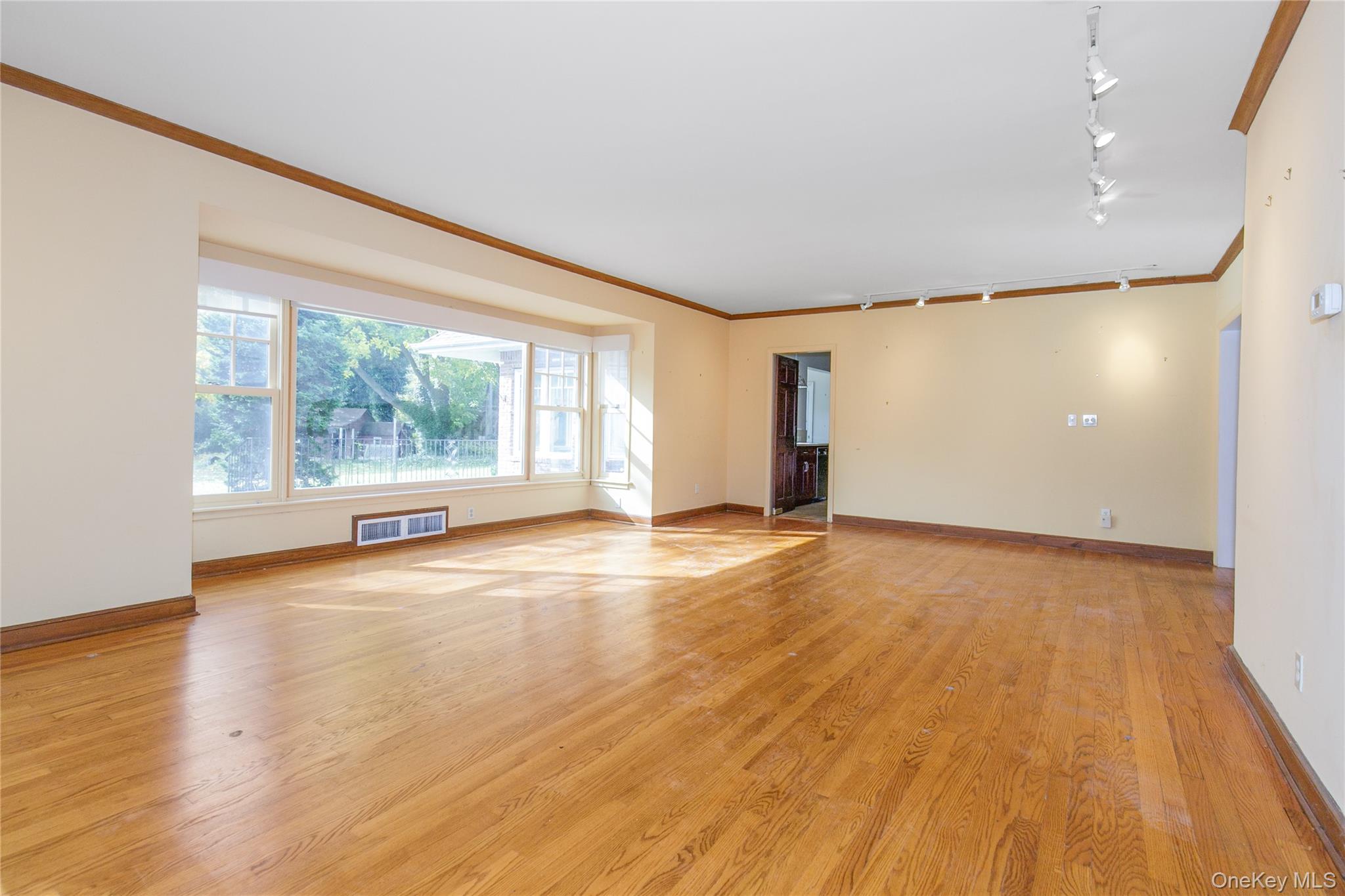 18 Lighthouse Road Kings Point, NY 11024 - Photo 4 of 36 an empty room with wooden floor and windows