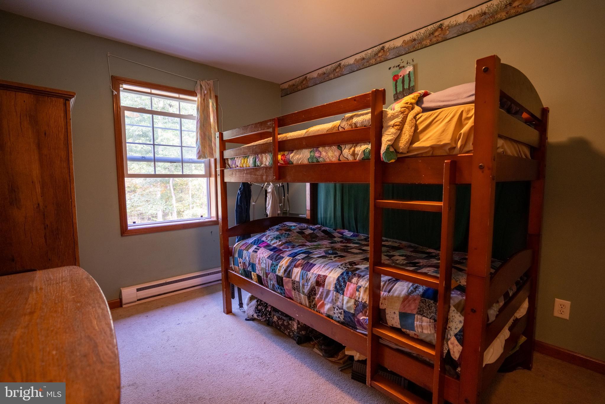 1950 Mesner Road Berkeley Springs, WV 25411 - Photo 24 of 34 a bed sitting in a bedroom next to a window