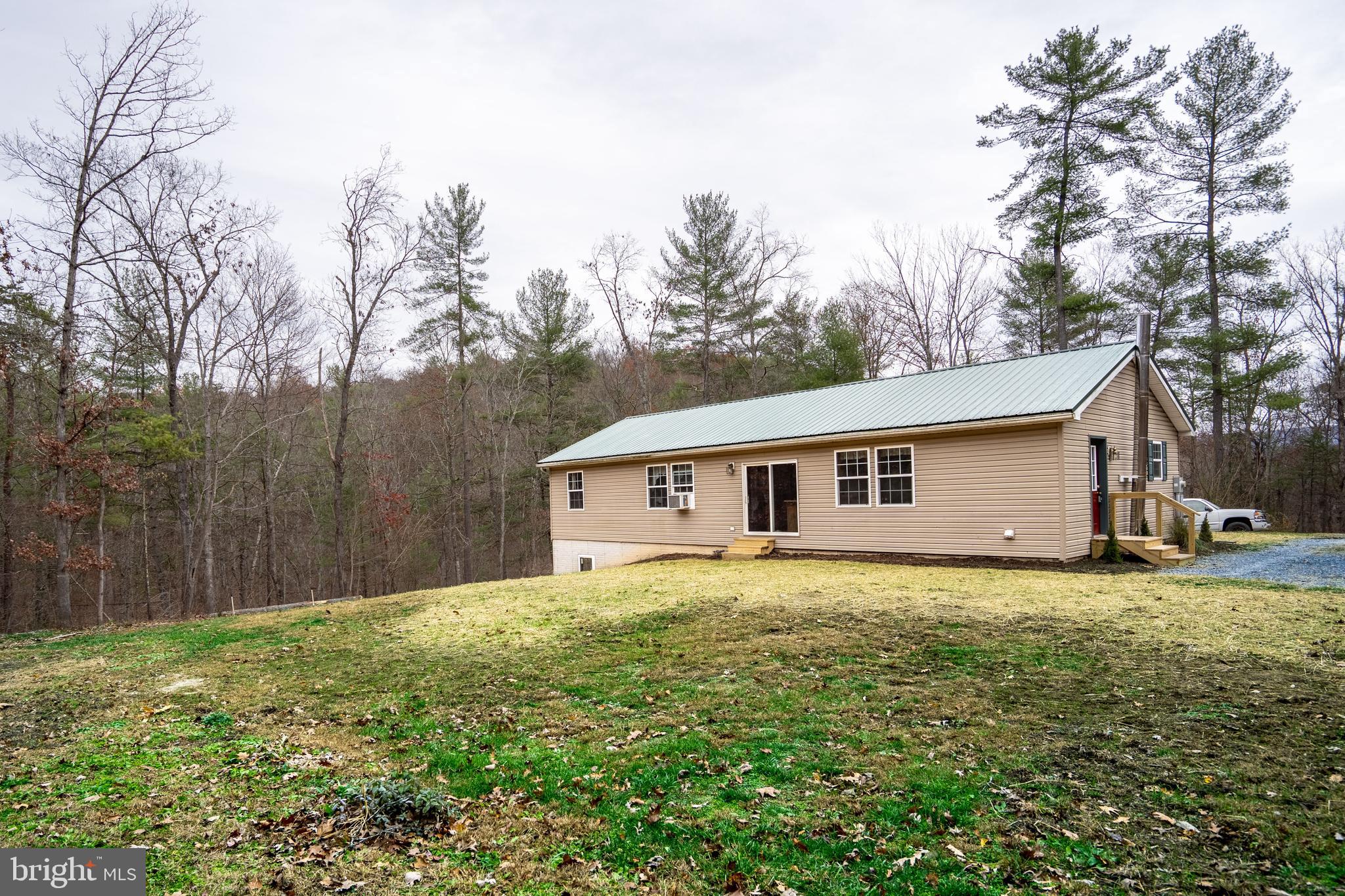 1950 Mesner Road Berkeley Springs, WV 25411 - Photo 7 of 34 a house that is sitting in the grass with large trees