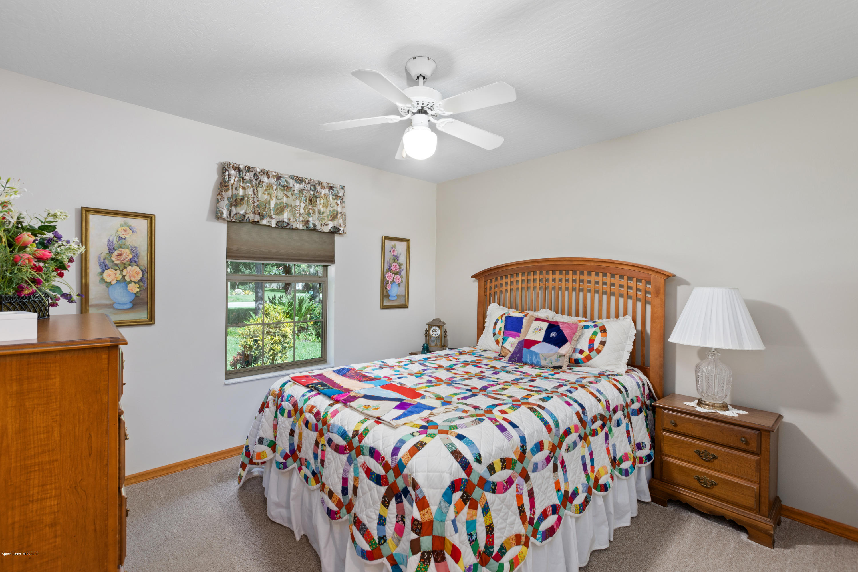 4255 Turtle Mound Road Melbourne, FL 32934 - Photo 13 of 46 a bedroom with a bed and a chandelier