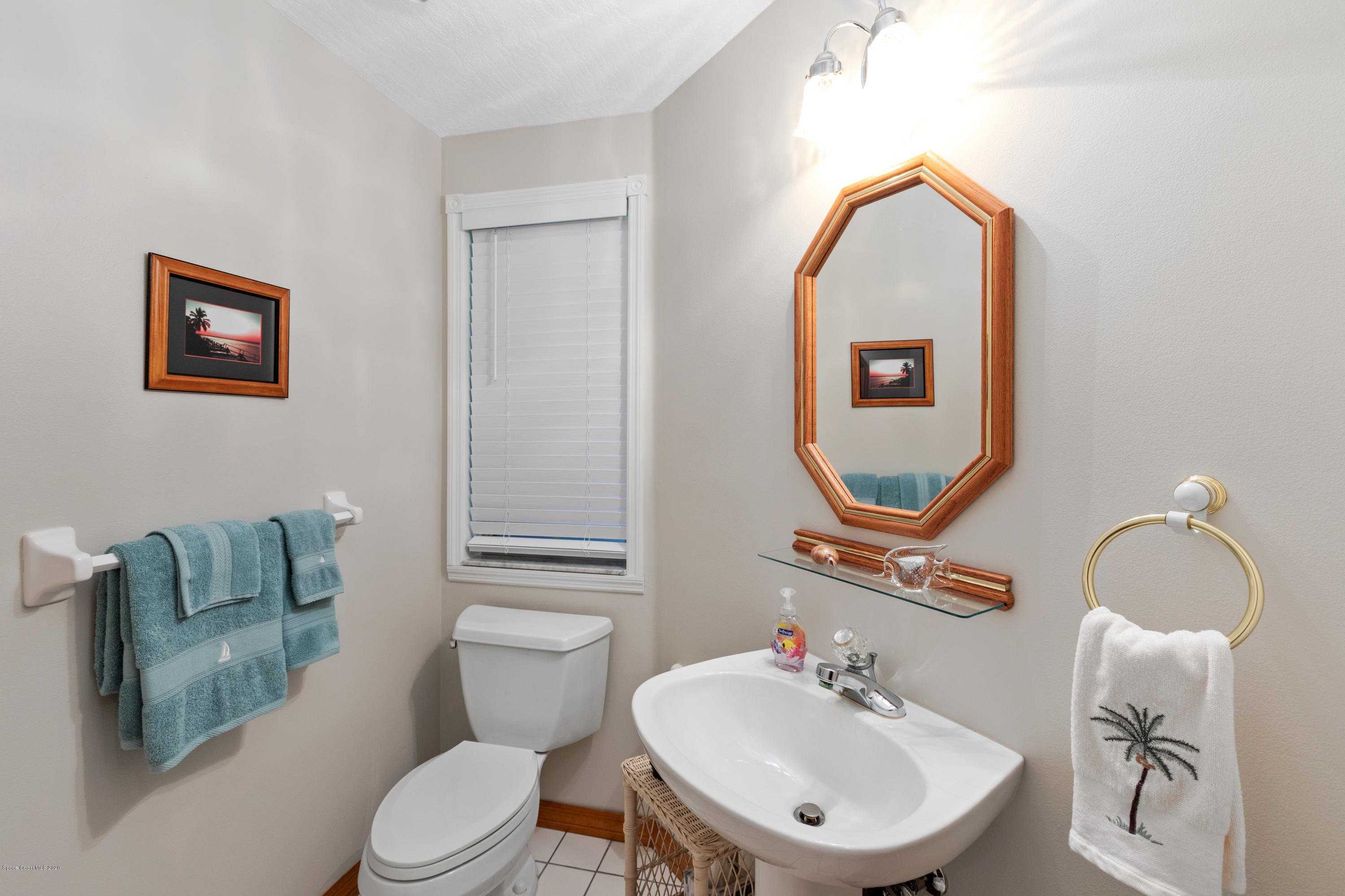 4255 Turtle Mound Road Melbourne, FL 32934 - Photo 17 of 46 a bathroom with a toilet sink and mirror