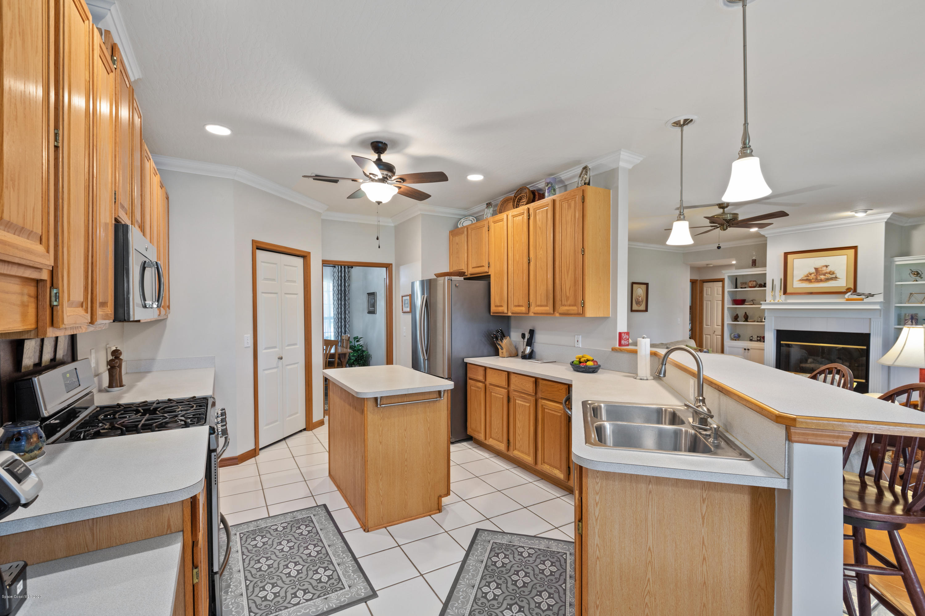 4255 Turtle Mound Road Melbourne, FL 32934 - Photo 22 of 46 a living room with stainless steel appliances granite countertop furniture a fireplace a rug and a window