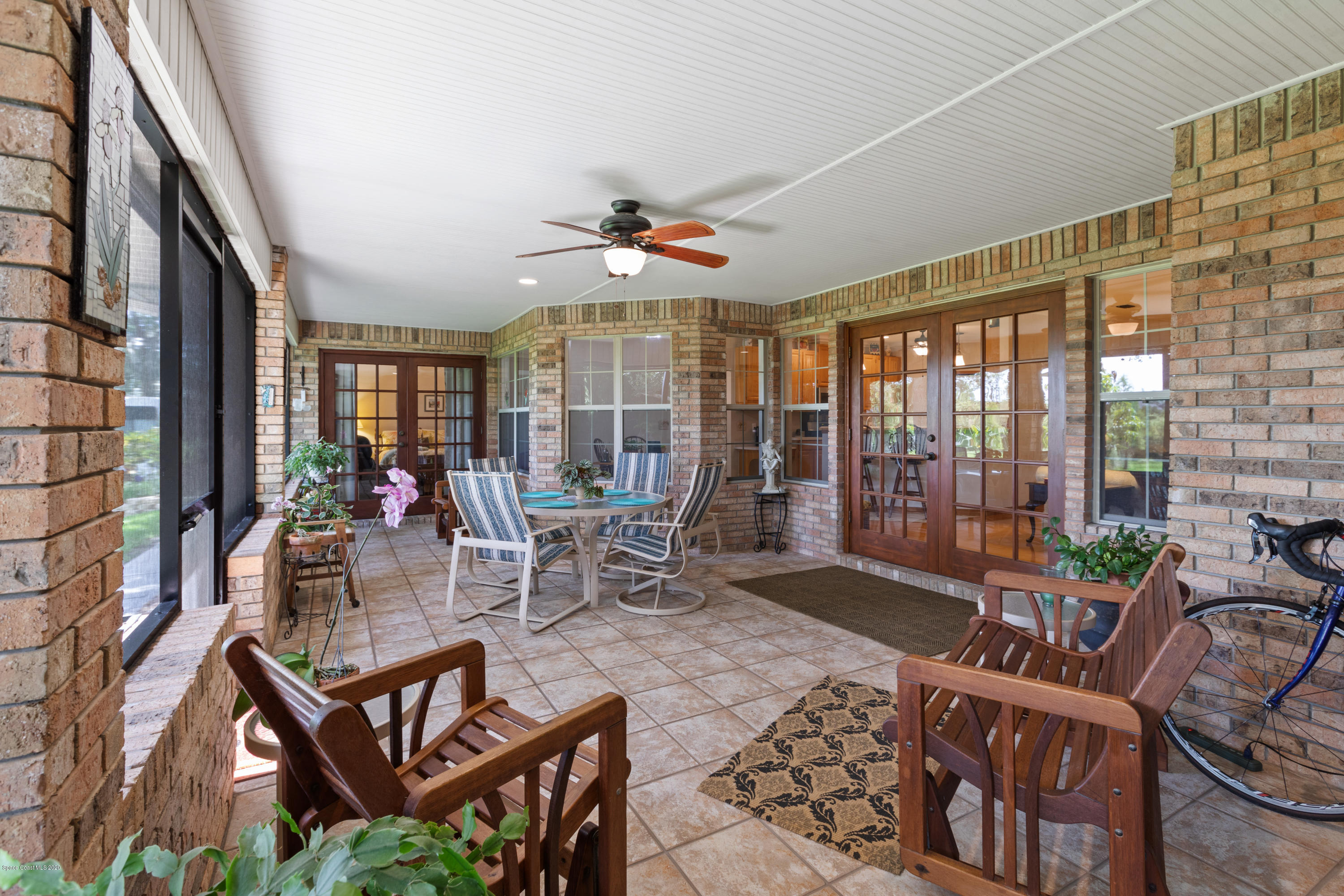 4255 Turtle Mound Road Melbourne, FL 32934 - Photo 33 of 46 a living room with furniture a lamp and a floor to ceiling window
