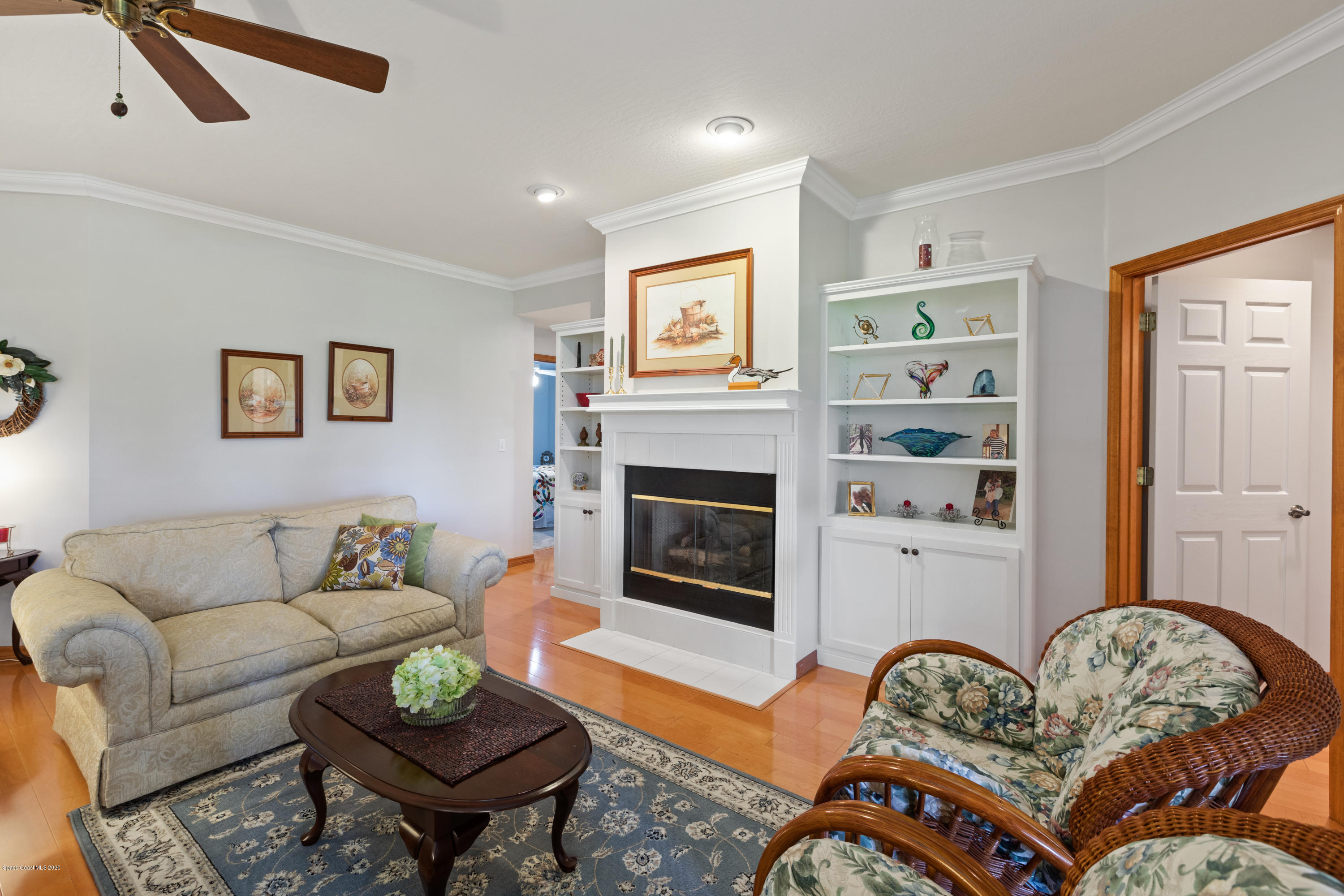 4255 Turtle Mound Road Melbourne, FL 32934 - Photo 10 of 46 a living room with furniture a flat screen tv and a fireplace