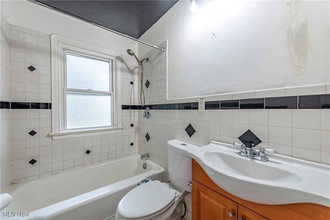 3201 Joslyn Road Cleveland, OH 44111 - Photo 11 of 36 Bathroom featuring bathtub / shower combination, vanity, and tile walls
