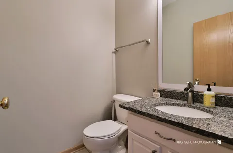 a bathroom with a granite countertop sink and a mirror with toilet