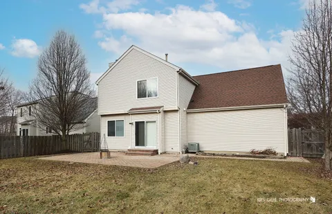 a view of a large white house with a yard and covered with snow