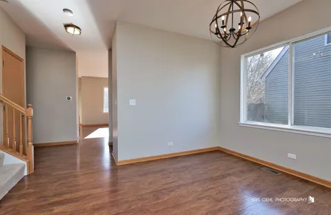 a view of a hallway with wooden floor and a window