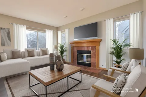 a living room with furniture a potted plant and a fireplace