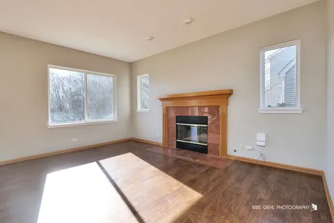 an empty room with windows and fireplace