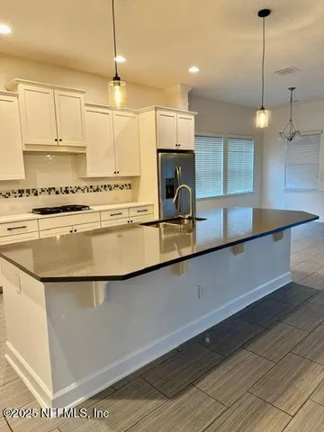 a view of a refrigerator in kitchen and a window