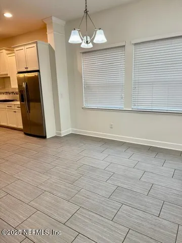 a kitchen with kitchen island granite countertop a stove a sink and white cabinets