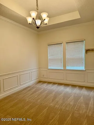 a view of hallway with stairs and a chandelier