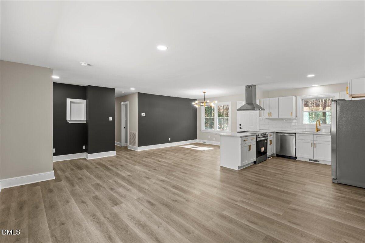 2501 Old Mill Road Rocky Mount, NC 27803 - Photo 9 of 41 a view of a kitchen with kitchen island wooden floors wooden cabinets and living room