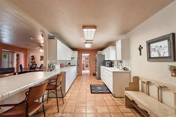 a living room with lots of furniture and view of kitchen
