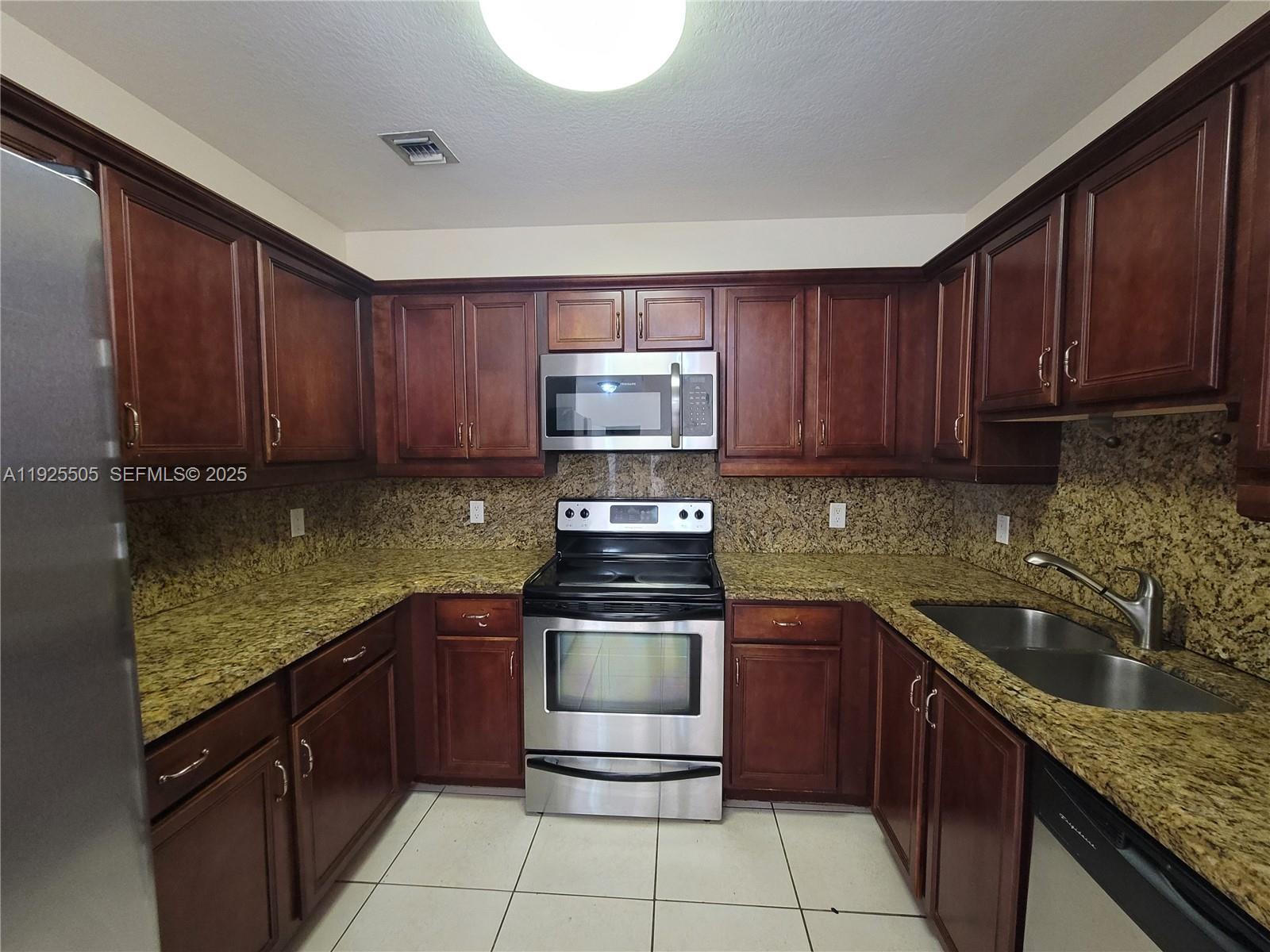 5271 Southwest 8th Street, Unit 411 Miami, FL 33134 - Photo 3 of 14 a kitchen with a sink and a stove top oven