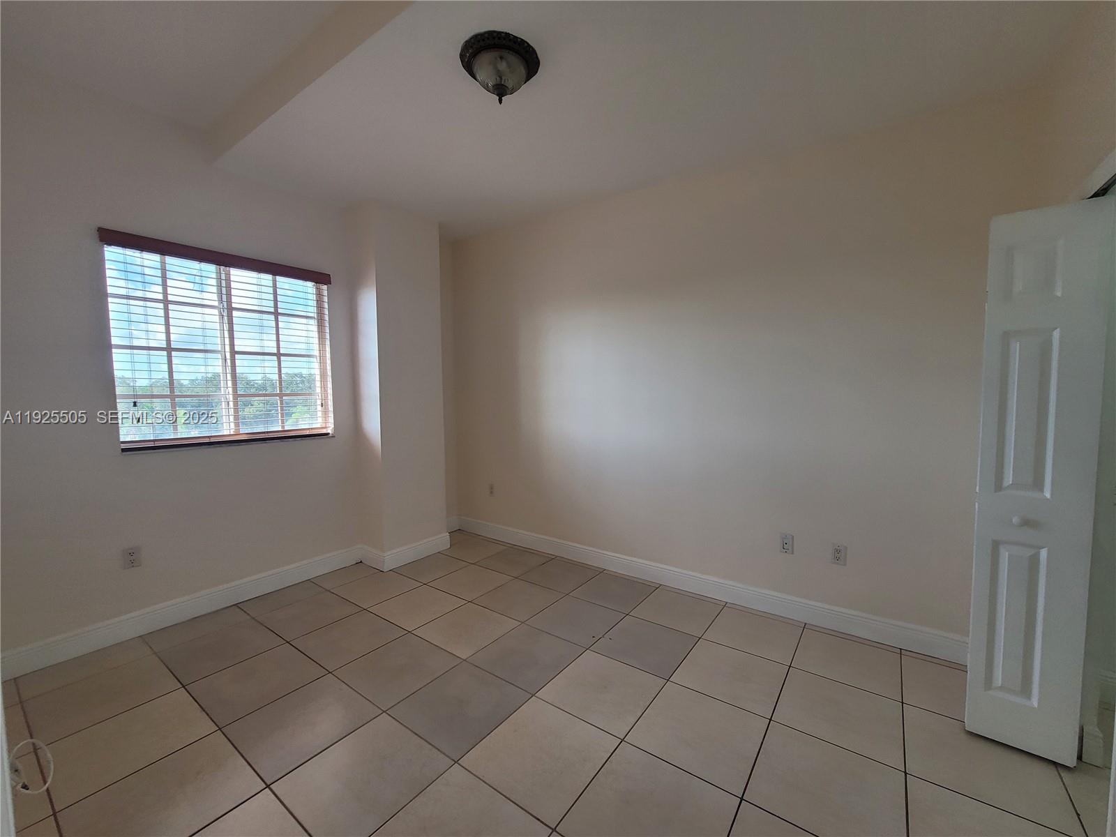 5271 Southwest 8th Street, Unit 411 Miami, FL 33134 - Photo 8 of 14 an empty room with windows