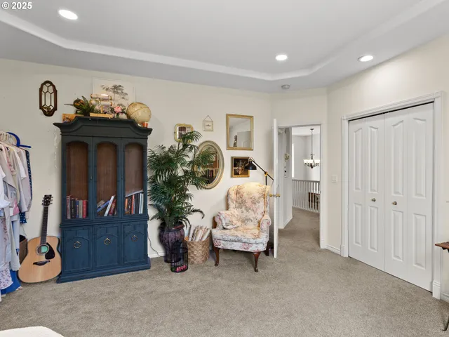 a spacious bedroom with a bed a table and large windows