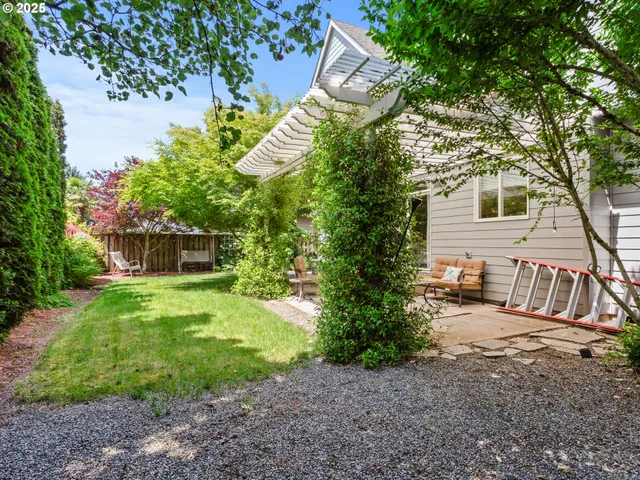 a view of a chair and table in backyard of the house