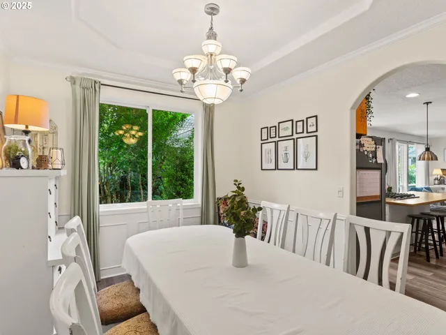 a dining room with wooden floor a chandelier a wooden table and chairs