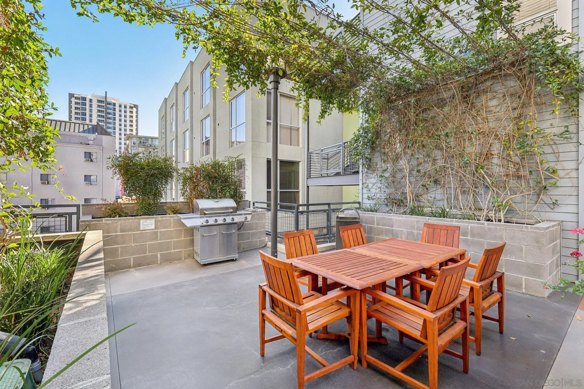 777 Sixth Avenue, Unit 135 San Diego, CA 92101 - Photo 30 of 38 a view of a patio with table and chairs potted plants and large tree