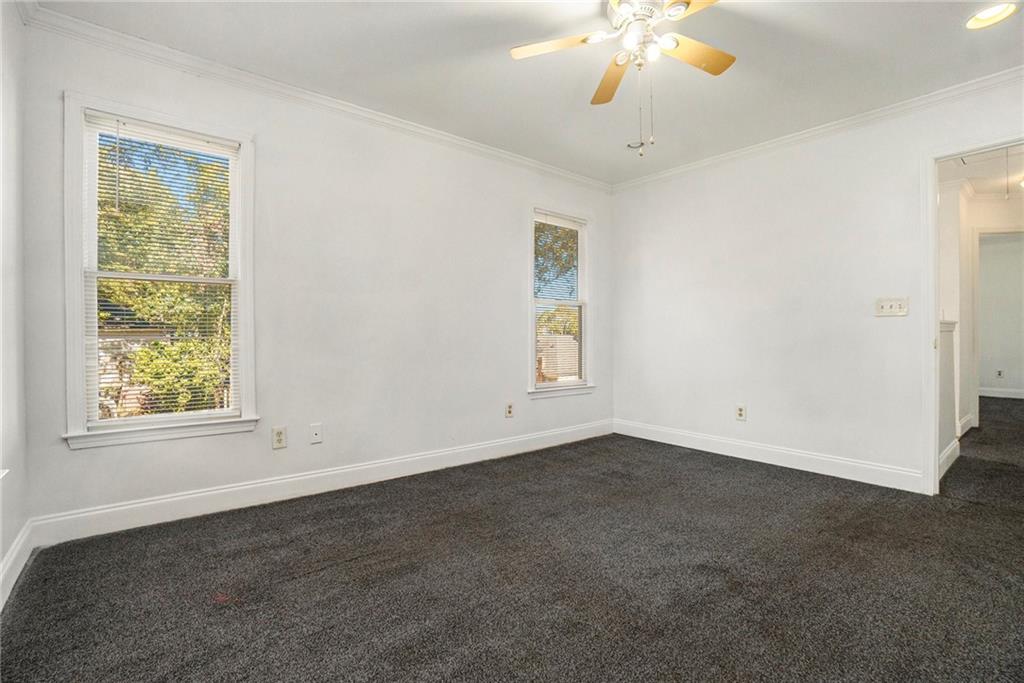 719 Magnolia Street Northwest Atlanta, GA 30314 - Photo 11 of 13 an empty room with a chandelier fan and windows
