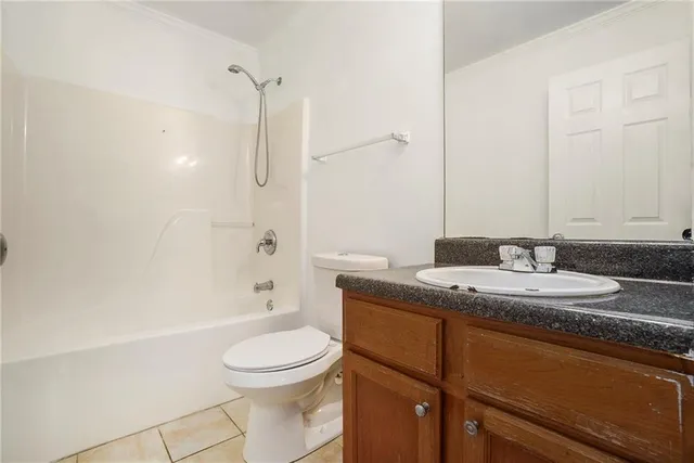 a bathroom with a granite countertop sink a toilet and shower