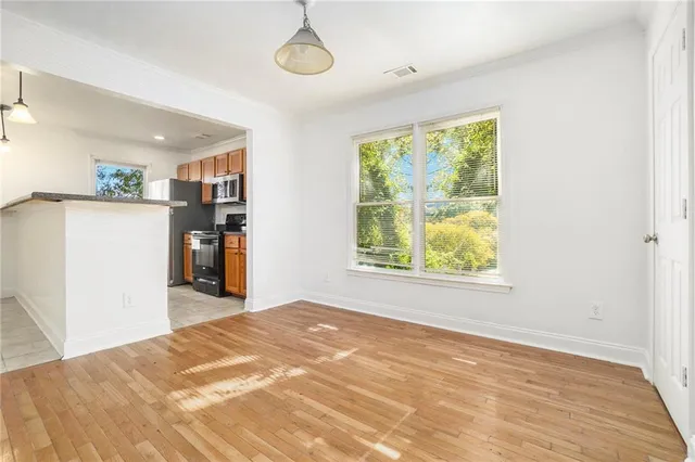 a view of a bedroom with wooden floor and a window