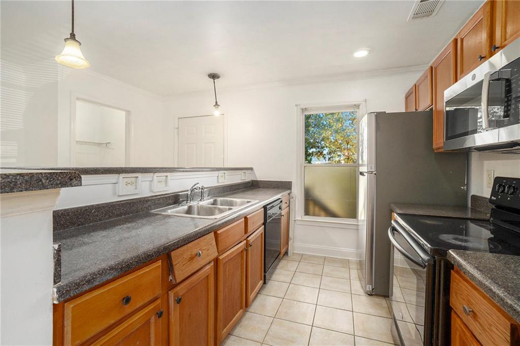 719 Magnolia Street Northwest Atlanta, GA 30314 - Photo 5 of 13 a kitchen with granite countertop a sink stove and cabinets
