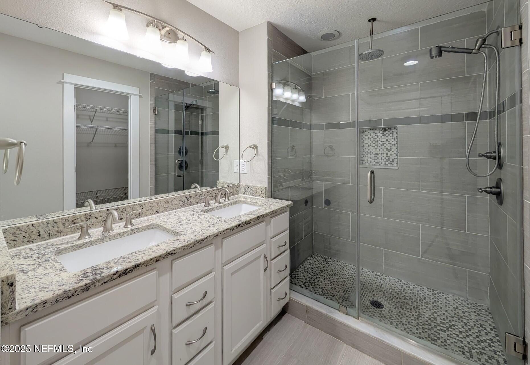 12950 Old St Augustine Road Jacksonville, FL 32258 - Photo 11 of 22 a bathroom with a granite countertop sink a mirror and shower