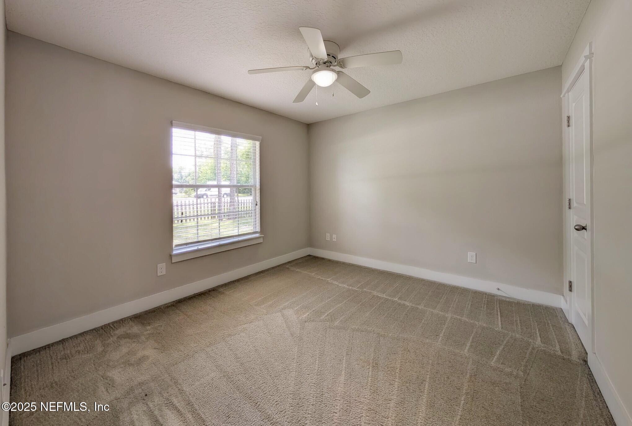 12950 Old St Augustine Road Jacksonville, FL 32258 - Photo 13 of 22 an empty room with windows and ceiling fan
