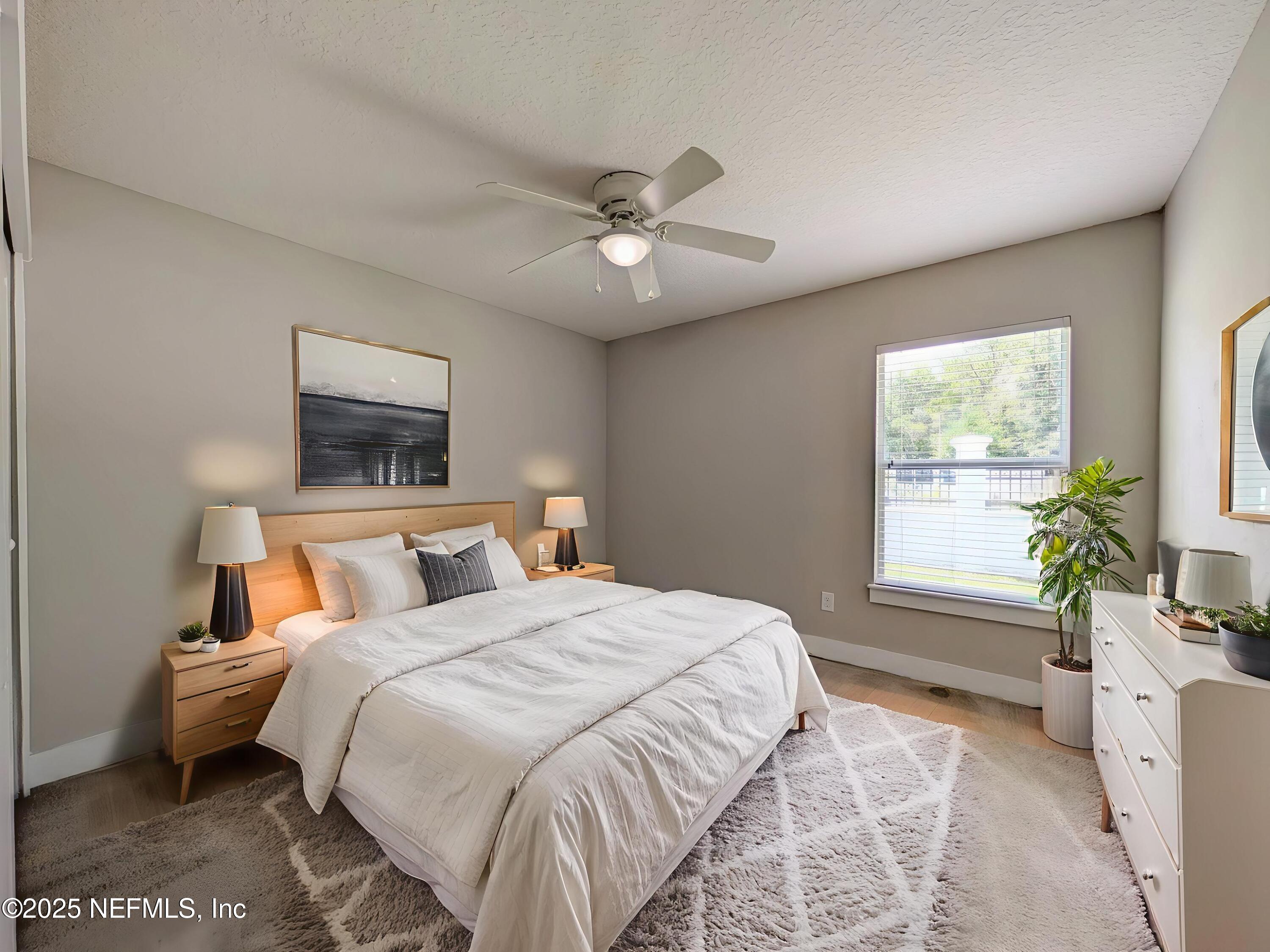12950 Old St Augustine Road Jacksonville, FL 32258 - Photo 16 of 22 a bedroom with a large bed and a chandelier