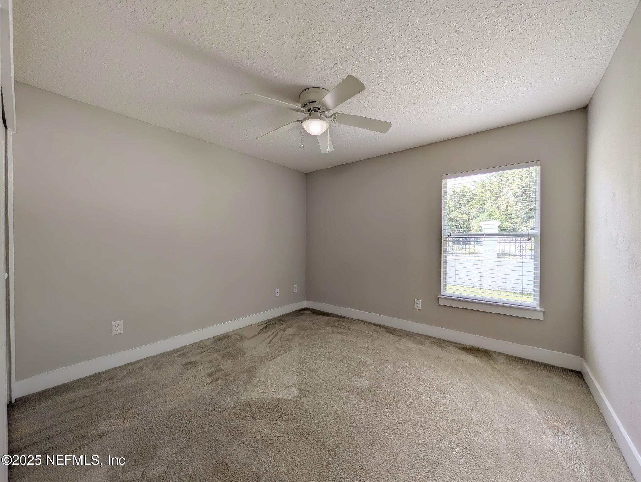 12950 Old St Augustine Road Jacksonville, FL 32258 - Photo 17 of 22 an empty room with a window and a ceiling fan