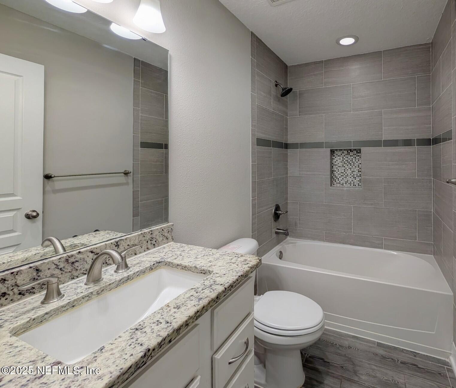 12950 Old St Augustine Road Jacksonville, FL 32258 - Photo 18 of 22 a bathroom with a granite countertop toilet sink and mirror