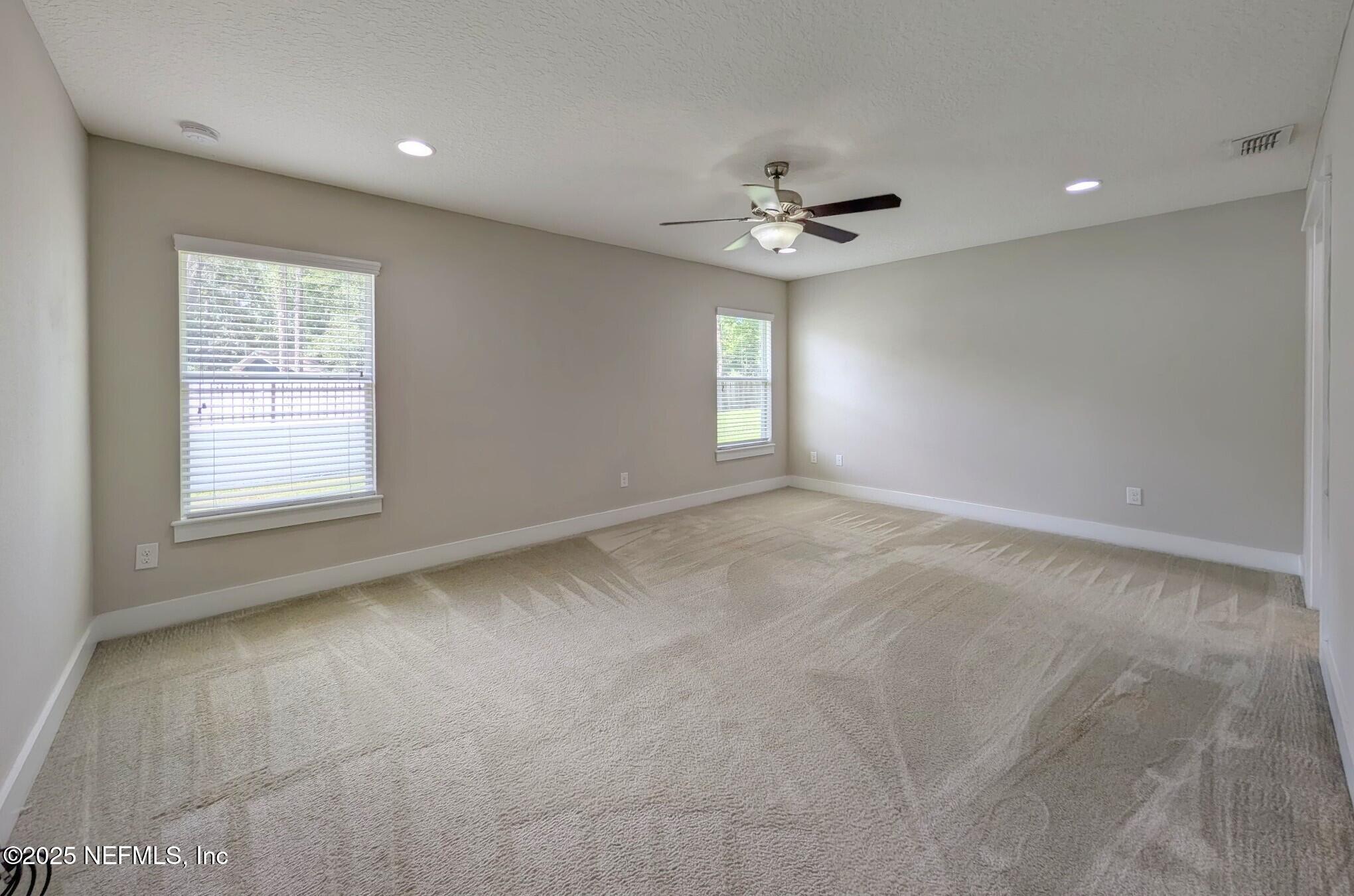 12950 Old St Augustine Road Jacksonville, FL 32258 - Photo 10 of 22 an empty room with windows and ceiling fan