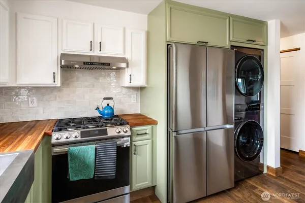 a kitchen with stainless steel appliances granite countertop a refrigerator a stove and a sink