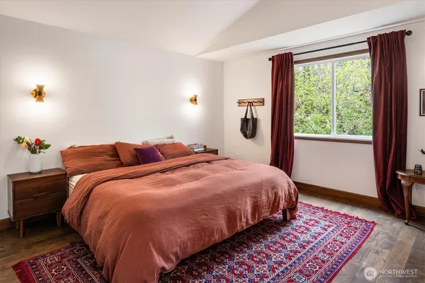a bed sitting in a bedroom next to a window