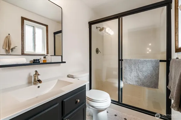 a bathroom with a sink a mirror a toilet and shower