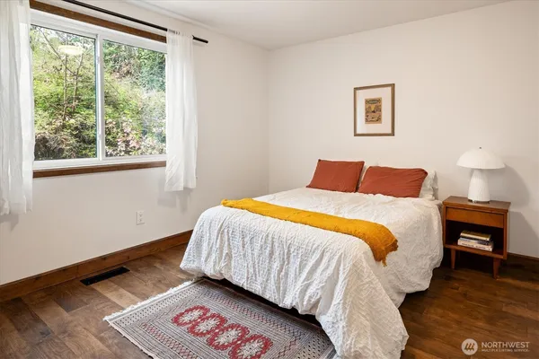 a bedroom with a bed and a lamp next to a window