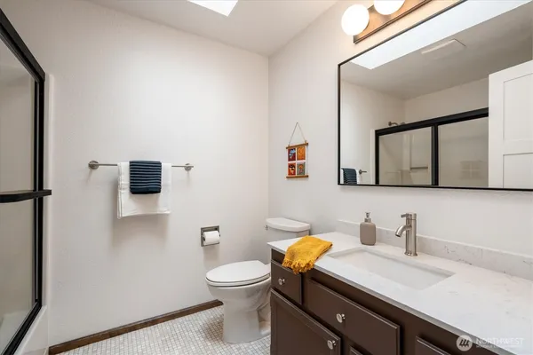 a bathroom with a granite countertop sink mirror vanity and toilet